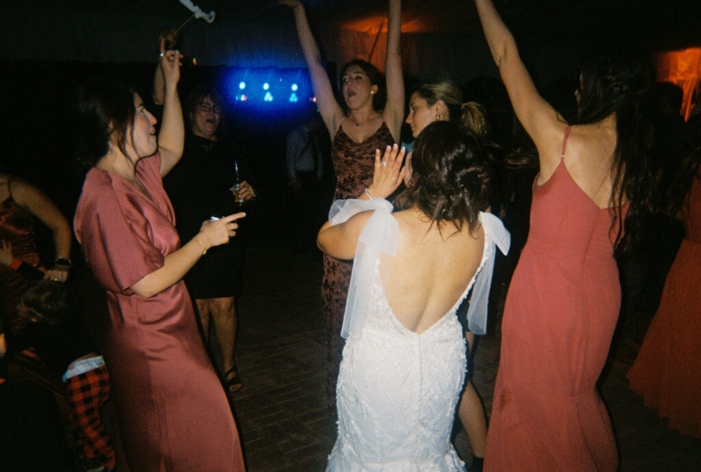 the bride dancing with the bridesmaids at her wedding