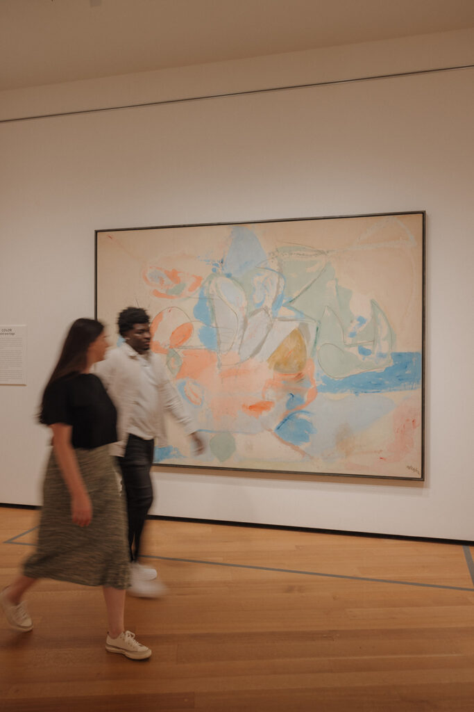 the engaged couple walking in the art gallery